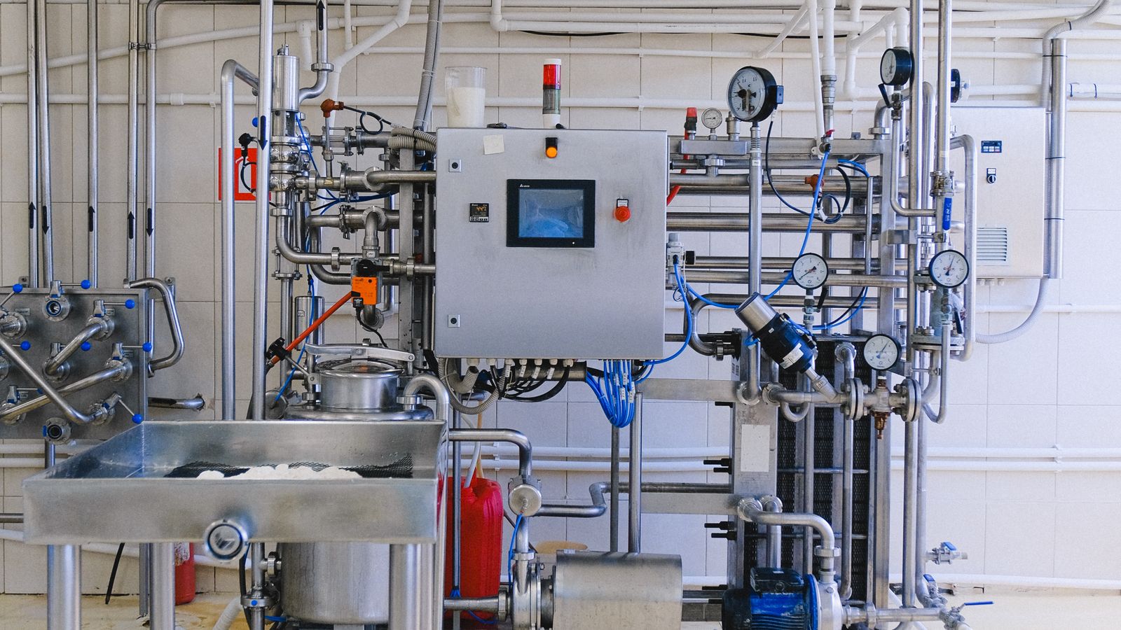 Industrial production machinery with stainless piping and controls